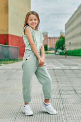 stylish teen girl in turquoise clothes on the street