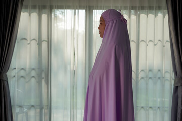 Muslim women praying In the foyer of the house during the coronavirus (COVID-19) outbreak, quarantine concept.