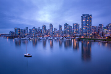 Obraz premium Vancouver downtown architecture and boat with water reflections at dusk