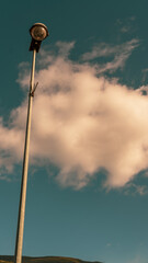 poste de iluminacion led con el cielo azul de fondo y una nuve 