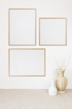 Three photo frame mockup on white wall © PawStudioArt