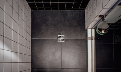 Floor drain, running water in shower, White and black tiles