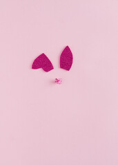 Bunny glitter rabbit  ears and nose on pastel pink background. Happy Easter minimal concept. Flat lay.