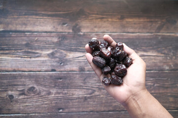 the concept of ramadan, hand holding date fruits 