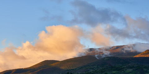 Fototapeta premium Panoramic view of the sunset sky with clouds on over the slopes of Mauna Kea in Hawaii.