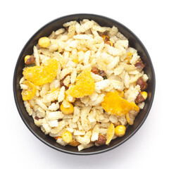 Close-Up of Crunchy Diet Mixture in a black Ceramic bowl made with Puffed Rice, Corn Flakes, and Curry leaves. Indian spicy snacks (Namkeen), Top  View