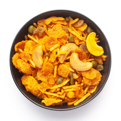 Close up of corn flex mixture Indian namkeen (snacks) on a ceramic black bowl. Top view
