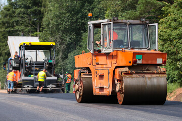 Construction site is laying new asphalt road pavement,road construction workers and road construction machinery scene. Road works