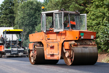 Construction site is laying new asphalt road pavement,road construction workers and road construction machinery scene. Road works