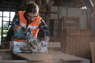 A young carpenter is working to order in his own wood factory. With peace of mind by using hand tools including saws, wood planers, hammers, measure tape and more.