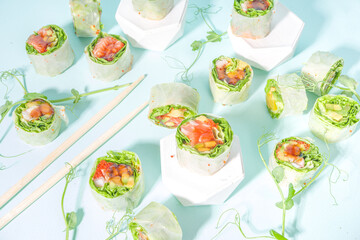 Mediterranean, nordic and keto diet concept. Sushi without rice, diet food with seafood, vegetables. Trendy asian sushi-styled Spring rolls on blue modern background