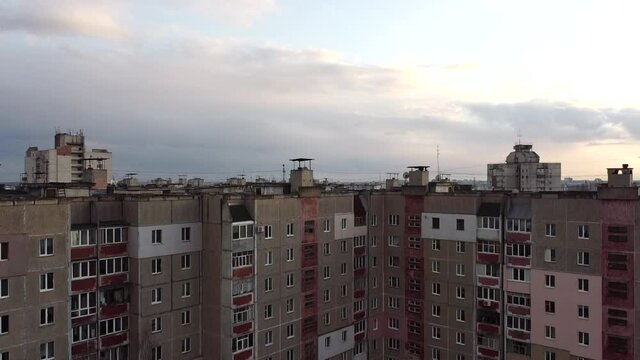 The drone rises above the roofs of old Soviet panel houses. Soviet architecture. Old multi-storey buildings, an array in the Chernobyl style. Blocks of the Russian ghetto, video from above.