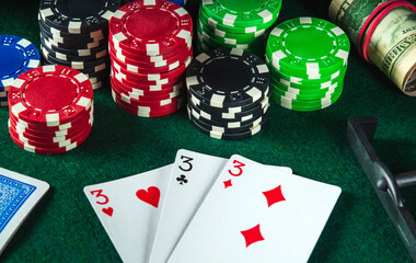 Poker cards with three of a kind or set combination in casino. Chips and money on the green table