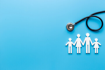 Medical care concept. Family figure with stethoscope, top view