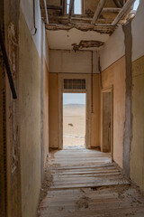 View at a corridor to outside in German Kolmanskop Ghost Town with the abandoned buildings in the Namib desert