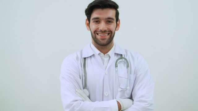 Portrait of doctor wearing lab coat, glove and stethoscope standing in the clinic looking at camera and crossed arm with smile. Confident man doctor. 