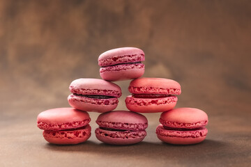 Obraz na płótnie Canvas Macaroons. Raspberry Macaroons on a brown background. Pink and red Macaroons. French cake. Place for your text.