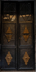 Old vintage dark brown door with golden decor in Istanbul