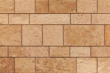 Building exterior brown granite block wall texture and background seamless