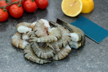 tiger prawns with tomatoes and lemon on the table