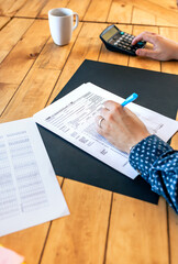 Unrecognizable male taxpayer filling in individual income tax return
