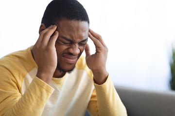 Closeup of black guy suffering from headache