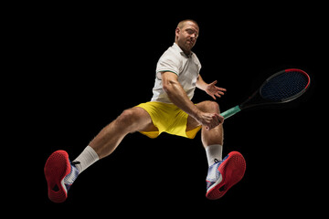 Fototapeta na wymiar Young caucasian tennis player in action, motion isolated on black background, look from the bottom. Concept of sport, movement, energy and dynamic.
