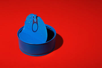 Blue tin can on dark red background