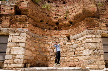 Young Uruguayan tourist posing by the concave wall of Ancient Celsus Library at Ephesus, Turkey
