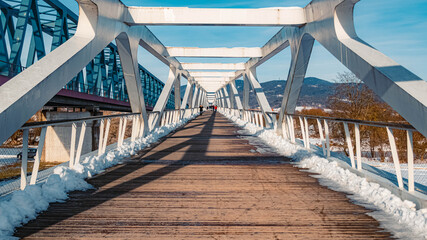 Fototapeta na wymiar Beautiful winter landscape with a perspective view of a pedestrian bridge near Deggendorf, Danube, Bavaria, Germany