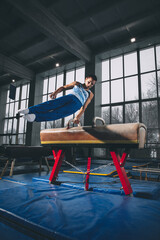 Little male gymnast training in gym, flexible and active. Caucasian fit little boy, athlete in...