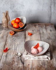 fresh orange ice cream scoops served in ceramic bowls on wooden table, copy space, seasonal dessert concept
