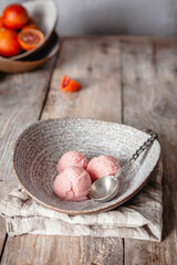 fresh orange ice cream scoops served in ceramic bowls on wooden table, copy space, seasonal dessert concept
