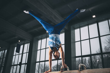 Little male gymnast training in gym, flexible and active. Caucasian fit little boy, athlete in...