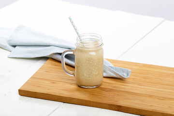 Smoothie setting with berries on wood table setup. Table cloth and ingredients. Straws.