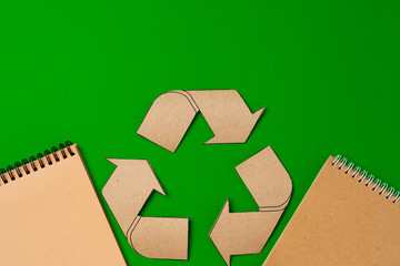 Paper recycling concept on green background top view