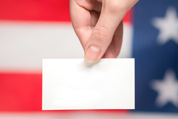 Empty card in woman hand. Copy space.  American flag background.