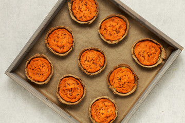 Carrot pies top view in a tray. Pastry with carrot and potato filling with caraway seeds. Rye flour homemade pastry.