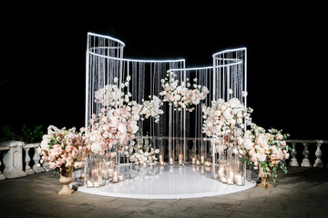 Wedding arch for wedding of newlyweds. Wedding celebration outdoors in night. Wedding ceremony decoration