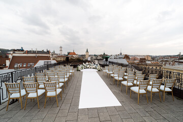 A marvelous place in the decorations and flowers for the wedding ceremony with white chairs on the roof of hotel
