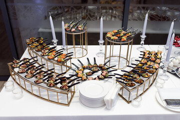 Luxury banquet table setting in restaurant. Table with the snacks and cocktails.