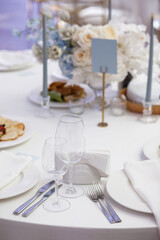 Festive wedding table setting with flowers, napkins, cutlery, glasses, bright summer table decor. Wedding decor