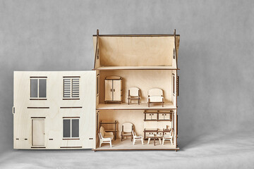 Cute doll house with toy furniture made of plywood details cut with laser machine tool stands with open wall on light grey