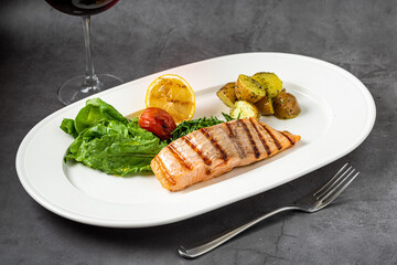 Grilled salmon fillet with vegetables mix. dark background