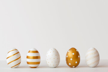 Golden eggs on a white background. Minimal easter concept.
