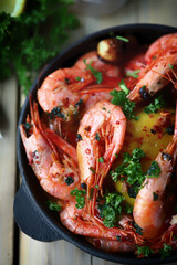 Hot fried prawns in shells with spices in a frying pan.