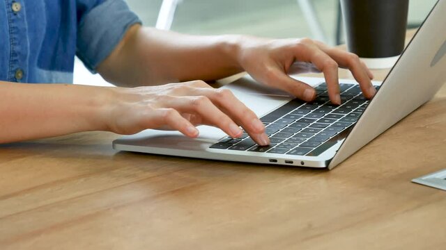 Woman working from home on laptop online meeting in home office. Entrepreneur asian business woman using notebook laptop sit on sofa technology new normal lifestyle. Happy woman typing keyboard laptop