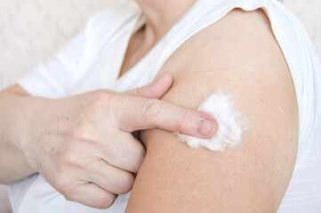 Woman getting vaccine with cotton wool in hand. Immunization. Vaccination. 