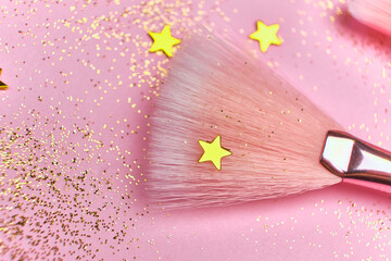 Festive magic make up brushes on pink background.