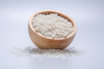 Rice in a wooden cup on a white background